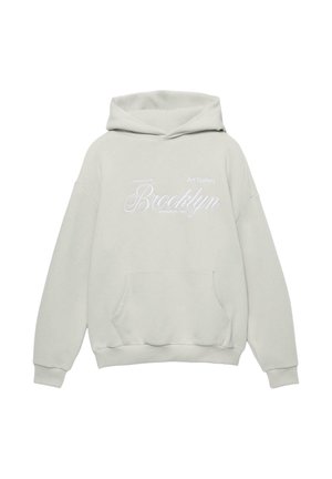 Svetlo siva kapučasta majica s prednjim žepom, koja sadrži bijeli izvezeni natpis: "Umjetnička galerija Brooklyn osnovana 1991." Mekana tkanina.