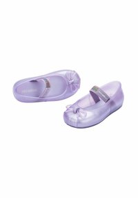 Bailarinas de color púrpura claro hechas de material brillante presentan un lazo en la punta y una cinta brillante. Suela plana diseñada para mayor comodidad.