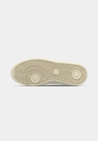 Suola di sneakers in gomma bianca con motivo di grip testurizzato, accenti circolari e design a spina di pesce. Presenta un branding minimale sul lato.