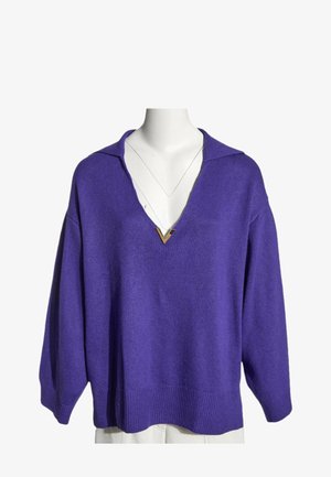 Jersey de punto morado de manga larga con cuello en V profundo en maniquí, complementado con un collar de cadena delgada con un colgante dorado en forma de V.