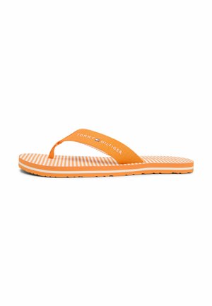 Tongs à rayures orange et blanches avec bride en tissu arborant le logo Tommy Hilfiger sur fond blanc.