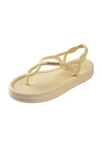 Sandale beige Havaianas avec semelle texturée, brides torsadées, lanière d’orteil et bride arrière pour un maintien sécurisé.