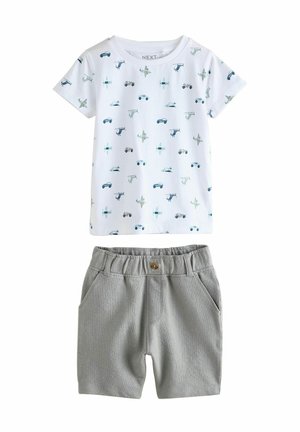 Kortsleeve vit t-shirt med blå fordonsmönster, tillsammans med grå shorts med resårmidja och framfickor.