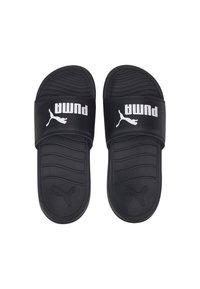 Black slide sandals with a textured sole, featuring a wide strap displaying the Puma logo in white. Smooth material with horizontal grooves.