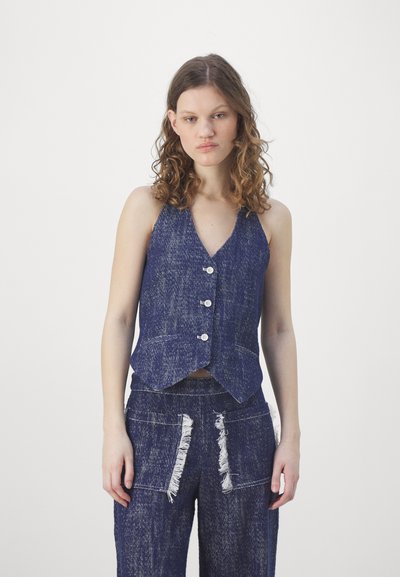 Blå denimvest med V-hals, frontknapper og to lommer, paired med matchende slitte denimbukser med frynse-detaljer.