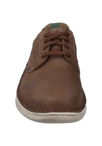 Bruine leren veterschoenen met een ronde neus, gestikte details en een lichtgekleurde rubberen zool. Groene accenten op de tong.