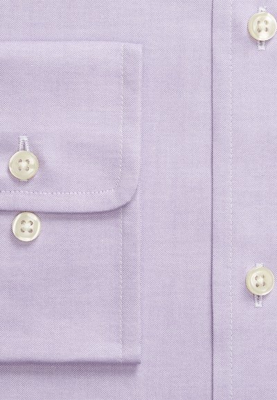 Gaiši violeti krekla tuvplāns, rādot salocītu aproci ar divām baltām pogām un da ļu no priekšējā plāksnītes ar vēl vienu pogu.