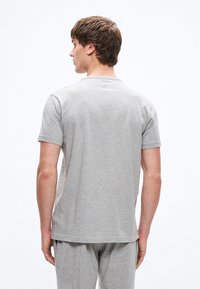 Halli puuvillane T-särk lühikeste varrukatega, ümmarguse kaeluse ja lõdva lõikega. Sile tekstuur ja minimaalsed õmblused seljal.