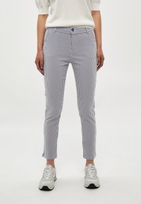 Pantalon à rayures blanches et bleu marine, en tissu léger. Doté d'une fermeture par bouton, de poches avant et d'une coupe longueur cheville.