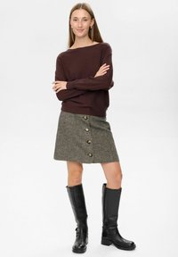 Brauner Strickpullover, grauer Tweed-Rock mit Knopfdetails und schwarze kniehohe Stiefel. Glatte Textur, klassisches Design.