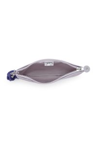 Lavendel lynlås-pung med en lilla pom-pom nøglering, åben for at vise et enkelt gråt indvendigt rum og et mærke indeni.