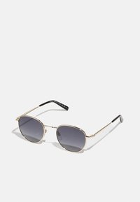 Gold metal sunglasses with rounded lenses, dark gradient tint, slim temples, and a black plastic tip on each arm.