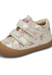 Scarpe in tessuto metallizzato oro con motivi di uccelli in colori pastello, dotate di due cinture in Velcro e una suola in gomma marrone per una presa migliore.