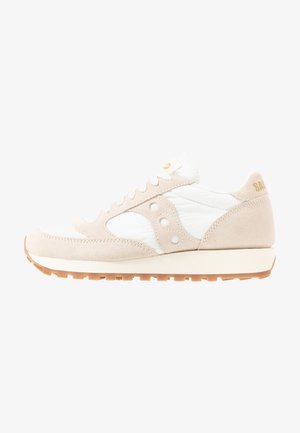 Beige und weiße Sneaker mit Obermaterial aus Wildleder und Mesh, mit runder Zehenkappe, Schnürverschluss und auffälligem Seitenlogo sowie Gummisohle.