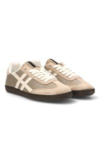 Zapatillas beige con parte superior de ante y tejido, cordones blancos y suela de goma. Presentan un diseño distintivo de rayas blancas en el lado.