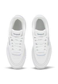 Baskets de sport blanches avec une tige en cuir lisse, une boîte à orteils perforée et un système de laçage. Présente des accents gris subtils et un logo.