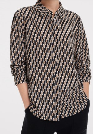 Camicia a maniche lunghe in un tessuto leggero con un motivo geometrico nei colori nero, marrone e crema, con colletto a punta e bottoni.