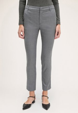 Grå skræddersyede bukser med en glat overflade, sidelommer og et slim fit. Sammen med sorte flade sko med ankelremme.