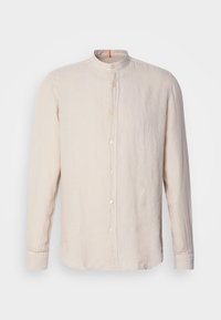 Chemise en lin beige à manches longues avec col officier et boutons sur le devant, présentée sur un fond clair uni.