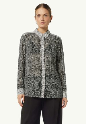 Schwarz-weiße Hemd mit Zebra-Muster, ausgestattet mit einem transparenten Stoff, Kragen und langen Ärmel mit kontrastierenden Bündchen.