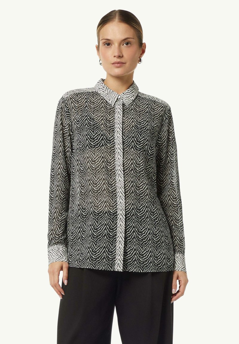 Black and white button-up shirt with a zebra print, featuring a sheer fabric, collar, and long sleeves with contrasting cuffs.