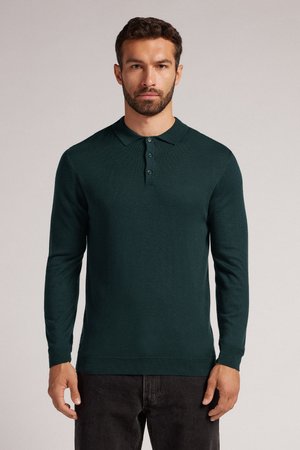 Mörkgrön långärmad polo skjorta med en texturerad stickning, med en ribbad krage, tre-knappsstängning och en figurnära siluett.
