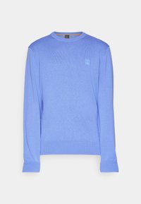 Ljusblå tröja, långa ärmar, rund hals, ribbad muddar och nederkant, med en liten logopatch på bröstet. Slät stickad textur.