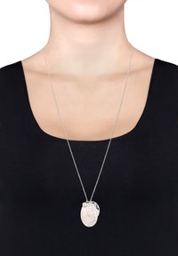 Sølv kæd necklace med en oval vedhæng med blomstermotiv og en glat, lysfarvet accent.