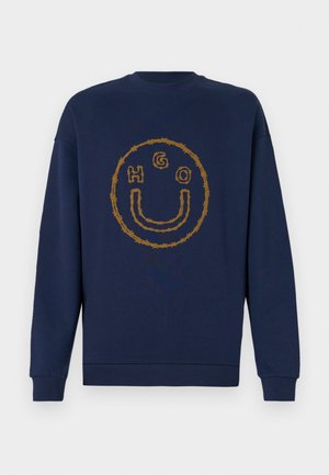 Marineblaue Sweatshirt mit einem Dornendrahtdesign, das ein Smiley-Gesicht bildet, und den Buchstaben H, G und O innerhalb des Kreises auf der Brust.