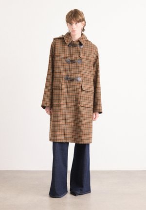 Bruine geruite trenchcoat met een capuchon, voorzien van grote zakken, togglesluitingen en een losse pasvorm. Gecombineerd met wijde, donkere spijkerbroeken.
