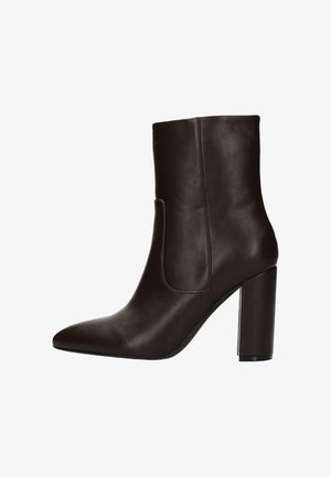 Bottines en cuir marron avec un bout pointu et un talon carré de 10 cm. Texture lisse ; présente un design découpé sur le côté pour un style supplémentaire.