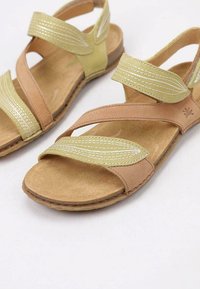 Sandali in pelle marrone e verde con un design a strappy, caratterizzati da cinturini texturizzati e una soletta beige imbottita. Suola piatta in gomma.
