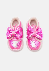 Rosa joggesko med en stor paljettbue, skinnende paljetter og en polstret såle. Overdelen er dekorert med rosa og hvite paljetter.