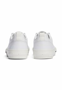 Sneakers bianchi con tomaia in pelle liscia, suola piatta bianca e tallone rinforzato. Presentano un logo sottile e dettagli di cucitura a contrasto.