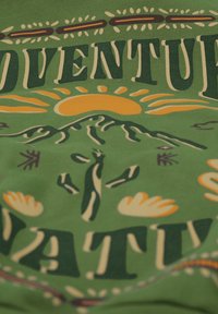 Grünes Baumwoll-T-Shirt mit fettem Text "ABENTEUER", Sonnen-, Berg-, Kaktus- und Blumendesigns in Gelb und Dunkelgrün.