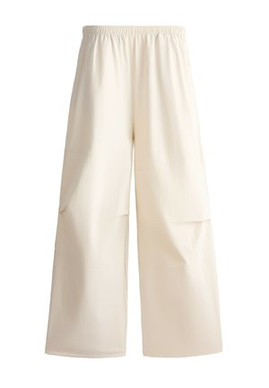 Pantalon ample couleur crème avec taille élastique et poches plaquées à l’avant, en tissu doux.