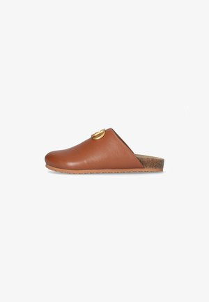 Scarpa slip-on in pelle marrone con punta arrotondata, suola in sughero e un accento circolare dorato sulla tomaia. Texture liscia con un design casual.