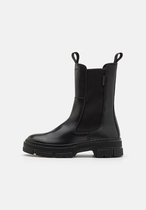 Ankle boot in black leather with elastic side panels and loop tabs. Features a chunky rubber sole for durability and grip.