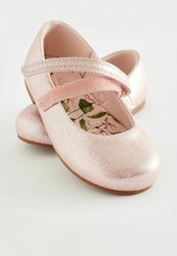 Rosa metalliska balettskor med rem, såsom en strukturerad yta och inlägg med blommönster. Rund tå och platta sulor.