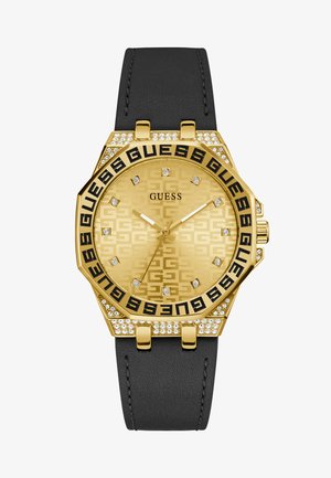 Orologio dorato con cassa ottagonale, cinturino in gomma nera, quadrante testurizzato, lettering nero e dettagli in cristallo attorno alla lunetta.