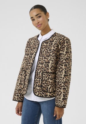 Leopard print jacket with black trim, featuring a round neckline, two front pockets, and long sleeves, worn over a white shirt.
