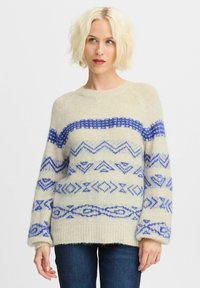 Pulover crem cu modele geometrice albastre, mâneci lungi și decolteu rotund. Textură moale și croială lejeră, cu manșete și tiv ondulate.