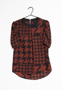 Blouse à motifs marron et noirs avec manches bouffantes, encolure ronde et ourlet arrondi. Dotée d'une fermeture éclair au dos et d'un tissu texturé.
