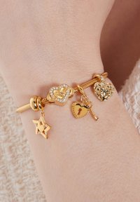 Gouden charm bracelet met hart, sleutel en ster charms, versierd met sprankelende accenten en ingewikkelde ontwerpen. Aanpasbare haaksluiting zichtbaar.