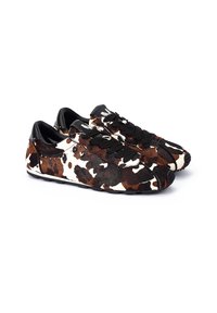 Zapatillas de cuero de vaca con un patrón manchado en marrón y blanco, detalles en cuero negro y cordones negros. Textura suave con un diseño de suela mínima.
