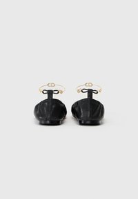 Balerini negre din piele cu vârf rotund, design gathered și o curea aurie la gleznă cu detaliu în formă de fundă. Talpă plată, stil minimalist.