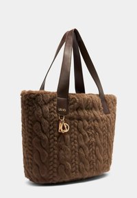 Borsa a tote in pelliccia sintetica marrone con texture intrecciata, manici in pelle marrone scuro e accessori in oro. Presenta un dettaglio con etichetta del brand.
