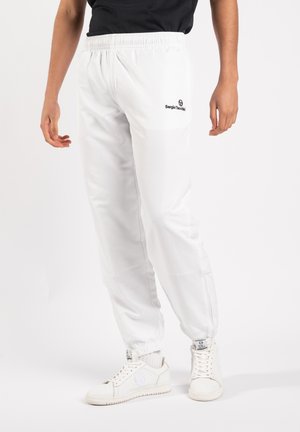White elastic-waist jogger pants with a tapered fit, featuring a black logo on the left thigh and ribbed cuffs at the ankles.