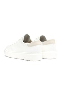 Baskets blanches en cuir avec une finition texturée, présentant une accent beige au talon, des lacets plats et une épaisse semelle en caoutchouc blanc.