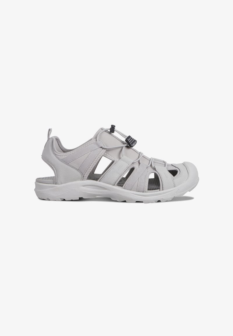 Ljusgrå sandal med öppen design, tillverkad av syntetiska material. Har justerbar snörning med dragrem och en förstärkt tåhätta.